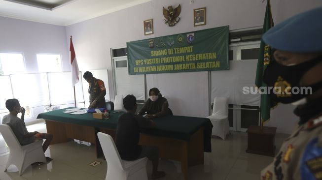 Warga pelanggar PSBB mengikuti sidang di tempat usai terjaring operasi yustisi protokol kesehatan pencegahan Covid-19 di SMKN 57 Jakarta, Kamis (17/9/2020). [Suara.com/Angga Budhiyanto]