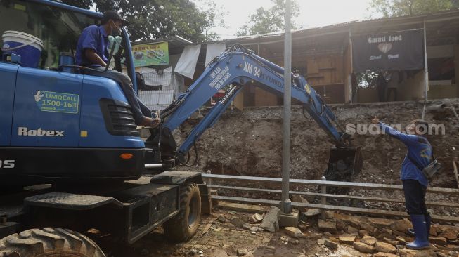 Petugas Suku Dinas Sumber Daya Air Jakarta Selatan dibantu alat berat mengevakuasi material longsor di Rumah Pohon Jagakarsa, Jakarta, Kamis (17/9/2020). [Suara.com/Angga Budhiyanto]