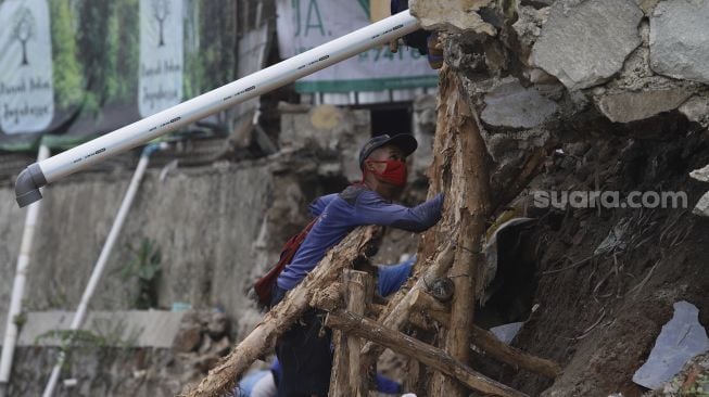 Petugas Suku Dinas Sumber Daya Air Jakarta Selatan membangun kembali turap yang longsor di Rumah Pohon Jagakarsa, Jakarta, Kamis (17/9/2020). [Suara.com/Angga Budhiyanto]