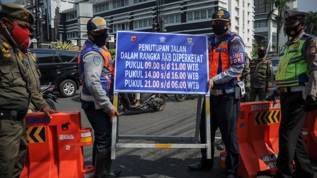 Petugas Dinas Perhubungan membawa papan informasi saat penutupan jalan Asia Afrika, Bandung, Jawa Barat, Jumat (18/9/2020). [ANTARA FOTO/Raisan Al Farisi]
