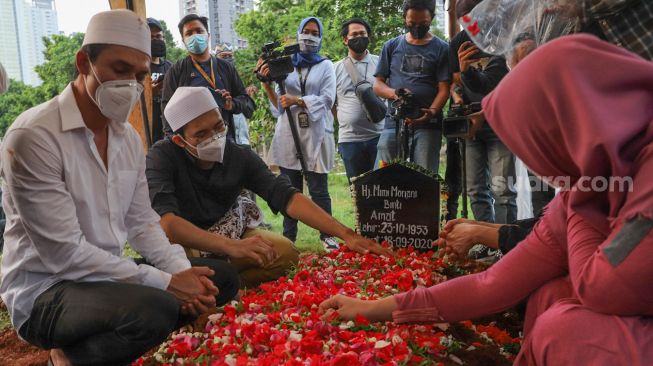 Aktor Indra Bruggman dan keluarga berdoa di atas pusara sang Ibu di TPU Menteng Pulo I, Jakarta Selatan, Jumat (18/9). [Suara.com/Alfian Winanto]