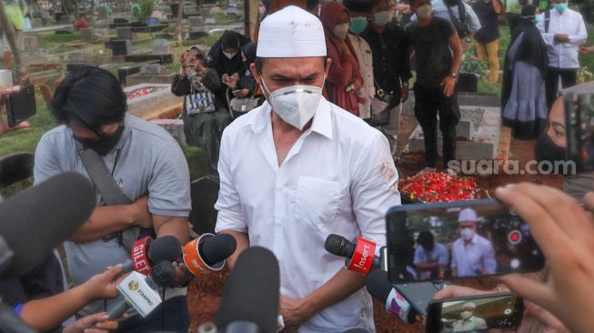 Aktor Indra Bruggman menemui awak media usai pemakaman sang Ibu di TPU Menteng Pulo I, Jakarta Selatan, Jumat (18/9). [Suara.com/Alfian Winanto]