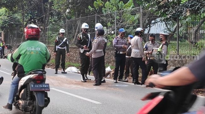 Aparat TNI-Polri saat melakukan olah TKP terkait kasus tewasnya Briptu Andry di Jalan Sapi Perah, Pondok Ranggon, Jaktim. (Suara.com/Bagaskara).