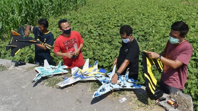 Pilot aeromodelling bersiap menerbangkan pesawat aeromodelling, di Kota Madiun, Jawa Timur, Sabtu(19/9/2020).  [ANTARA FOTO/Siswowidodo]