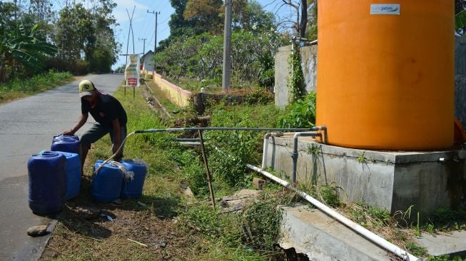 Warga mengambil air bersih di sumur program penyediaan air minum dan sanitasi berbasis masyarakat (Pamsimas), di Dusun Wonorejo, Desa Ngrimbi, Kecamatan Bareng, Kabupaten Jombang, Jawa Timur, Sabtu (19/9/2020). [ANTARA FOTO/Syaiful Arif]