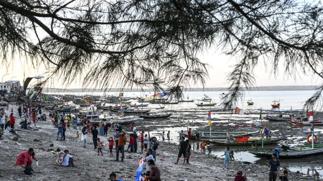 Warga bermain di pesisir pantai batu-batu Kenjeran, Surabaya, Jawa Timur, Minggu (20/9/2020). [ANTARA FOTO/M Risyal Hidayat]