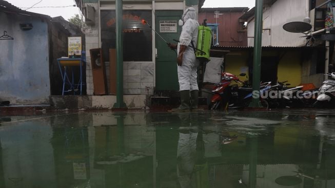 Relawan Siaga Bencana Berbasis Masyarakat (SIBAT) menyemprotkan cairan disinfektan di permukiman padat penduduk di kawasan Menteng Tenggulun, Jakarta, Minggu (20/9/2020). [Suara.com/Angga Budhiyanto]