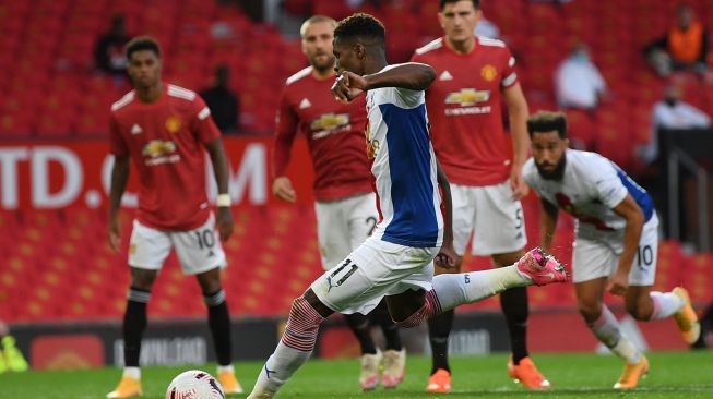 Striker Crystal Palace Wilfried Zaha mencetak gol kedua mereka dari titik penalti selama pertandingan sepak bola Liga Premier Inggris antara Manchester United melawan Crystal Palace di Old Trafford, Manchester, Inggris, Sabtu (19/9). [Shaun Botterill / POOL / AFP]
