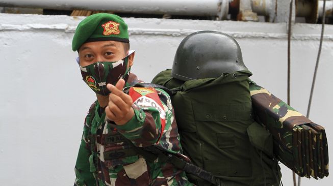 Seorang prajurit Yonif 133/Yudha Sakti mengacungkan salam cinta khas Korea Selatan saat menaiki tangga kapal di Pelabuhan Dwikora Pontianak, Kalimantan Barat, Minggu (20/9/2020). [ANTARA FOTO/Jessica Helena Wuysang]