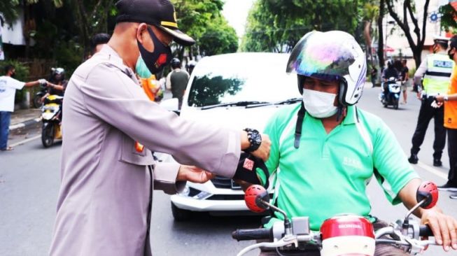 Aparat Polresta Banjarmasin membagikan masker kepada para pengguna jalan [ANTARA/Gunawan Wibisono]