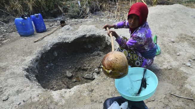 Warga mengambil air dari lubang buatan yang digali di dasar sungai di Dusun Asemrudung, Geyer, Grobogan, Jawa Tengah, Senin (21/9/2020). [ANTARA FOTO/Yusuf Nugroho]