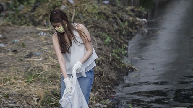 Seorang warga yang kedapatan tidak memakai masker menjalani hukuman membersihkan sungai saat terjaring Razia Penggunaan Masker di Banjarsari, Solo, Jawa Tengah, Rabu (16/9/2020). Pemerintah Kota Solo memberi sanksi kepada warga yang melanggar protokol kesehatan dengan membersihkan sungai, hal tersebut dilakukan untuk meningkatkan kedisiplinan warga agar selalu mengenakan masker ketika berada di tempat umum. [ANTARA FOTO/Mohammad Ayudha]