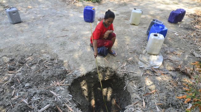 Warga mengambil air dari lubang buatan yang digali di dasar sungai di Dusun Asemrudung, Geyer, Grobogan, Jawa Tengah, Senin (21/9/2020). [ANTARA FOTO/Yusuf Nugroho]