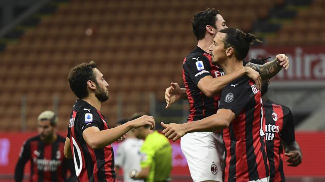 Penyerang AC Milan Zlatan Ibrahimovic merayakan bersama rekan satu timnya setelah mencetak gol kedua timnya melalui tendangan penalti selama pertandingan sepak bola Serie A Italia AC Milan melawan Bologna di Stadion San Siro, Milan, Italia, Selasa (22/9) dini hari WIB. [MIGUEL MEDINA / AFP]