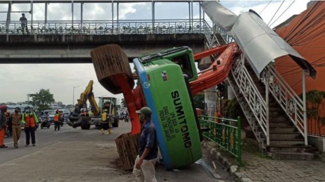 Ekskavator Nyangkut di JPO Kampung Melayu Sampai Terguling