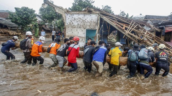 Sejumlah relawan gabungan mengevakuasi material kayu yang terbawa pasca banjir bandang di Kampung Cibuntu, Desa Pasawahan, Kecamatan Cicurug, Sukabumi, Jawa Barat, Selasa (22/9/2020). [ANTARA FOTO/Yulius Satria Wijaya]
