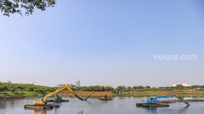 Suasana pengerukan lumpur di Waduk Ria Rio, Pulo Gadung, Jakarta Timur, Selasa (22/9). [Suara.com/Alfian Winanto]