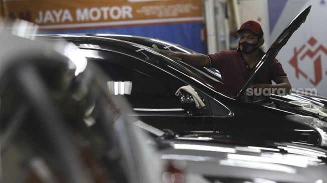 Pekerja melakukan perawatan mobil bekas di showroom penjualan mobil bekas WTC Mangga Dua, Jakarta, Rabu, (23/9/2020). [Suara.com/Angga Budhiyanto]
