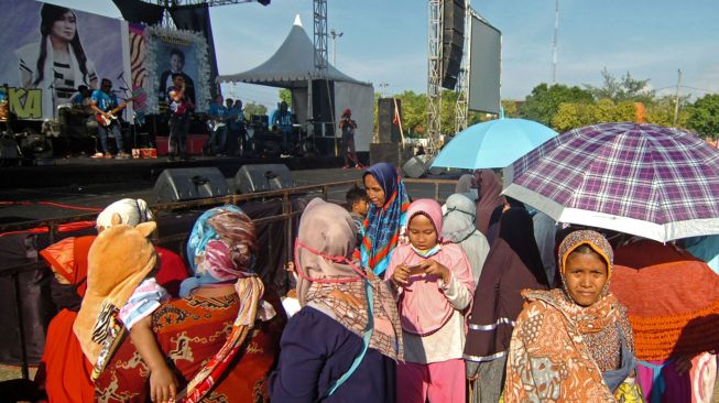 Sejumlah warga tidak mengenakan masker menyaksikan musik dangdut di Lapangan Tegal Selatan, Tegal, Jawa Tengah, Rabu (23/9/2020).  [ANTARA FOTO/Oky Lukmansyah]