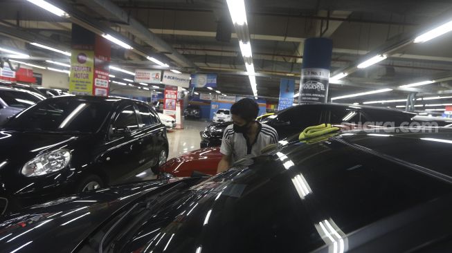 Pekerja melakukan perawatan mobil bekas di showroom penjualan mobil bekas WTC Mangga Dua, Jakarta. Sebagai ilustrasi pasar mobil second-hand [Suara.com/Angga Budhiyanto]