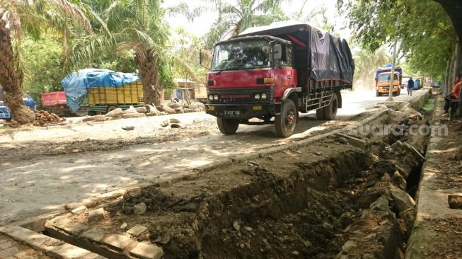 Tampak ruas Jalan Juanda, Kota Tangerang, mengalami longsor akibat dilalui oleh kendaraan bertonase besar, Kamis (24/9/2020). [Suara.com/Irfan Maulana]