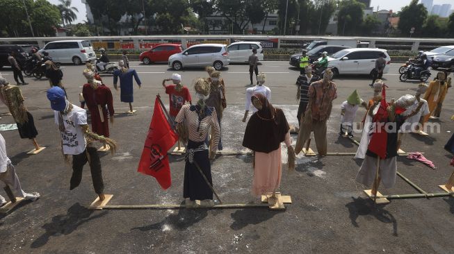 Puluhan boneka jerami atau orang-orangan sawah yang dipasang oleh massa Komite Nasional Pembaruan Agraria (KNPA) saat menggelar aksi Hari Tani Nasional  di depan gedung DPR RI, Jakarta, Kamis (24/9/2020). [Suara.com/Angga Budhiyanto]