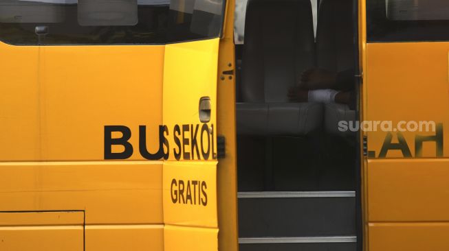 Seorang pasien tanpa gejala COVID-19 tertidur di dalam bus sekolah yang dioperasikan Dinas Perhubungan DKI Jakarta yang mengantar dari Puskesmas Kecamatan Makassar, Jakarta, Kamis (24/9/2020). [Suara.com/Angga Budhiyanto]