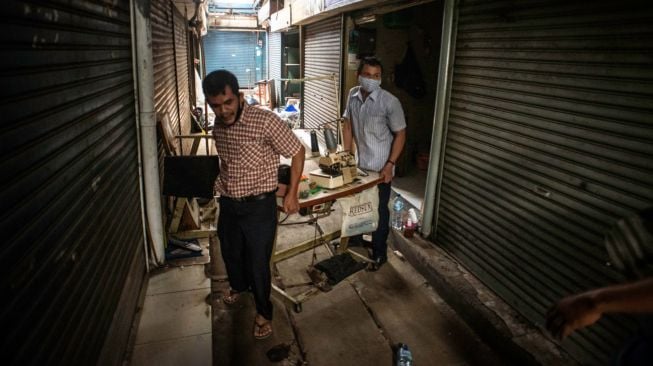 Pedagang membersihkan puing-puing sisa kebakaran di Pasar Cempaka Putih, Jakarta, Kamis (24/9/2020).[ANTARA FOTO/Aprillio Akbar]