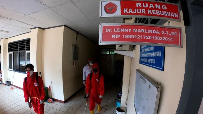 Relawan Palang Merah Indonesia (PMI) Provinsi Jambi berjalan keluar usai menyemprotkan cairan disinfektan di kawasan Fakultas Sains dan Teknologi, Universitas Jambi, Jambi, Jumat (25/9/2020).  [ANTARA FOTO/Wahdi Septiawan]