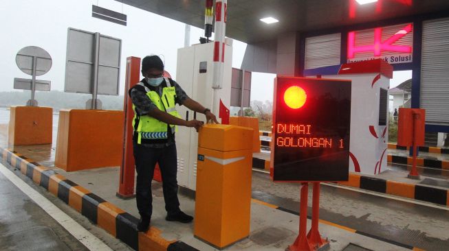 Seorang petugas memeriksa perlengkapan di pintu Tol Dumai di Dumai, Riau, Jumat (25/9/2020). [ANTARA FOTO/Aswaddy Hamid]