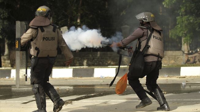 Aparat kepolisian menembakan gas air mata ke arah kerumunan mahasiswa Universitas Haluoleo Kendari saat unjuk rasa menuntut penuntasan kasus kematian dua mahasiswa di depan Markas Polda Sulawesi Tenggara, Kendari, Sulawesi Tenggara, Sabtu (26/9/2020). [ANTARA FOTO/Jojon]