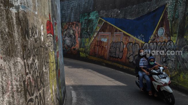 Mural - mural yang sudah kotor dan rusak menghiasi Terowongan Dipo KRL di Pancoran Mas, Depok, Jawa Barat, Sabtu (26/9). [Suara.com/Alfian Winanto]