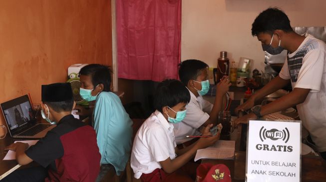 Empat orang siswa belajar secara online di Warkop Rizki, Pondok Aren, Tangerang Selatan, Banten, Rabu (29/7/2020). [Suara.com/Angga Budhiyanto]