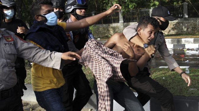 Aparat Kepolisian mengamankan seorang mahasiswa yang anarkis saat unjuk rasa mahasiswa menuntut penuntasan kasus kematian dua rekannya di depan Markas Polda Sulawesi Tenggara, Kendari, Sulawesi Tenggara, Sabtu (26/9/2020). [ANTARA FOTO/Jojon]