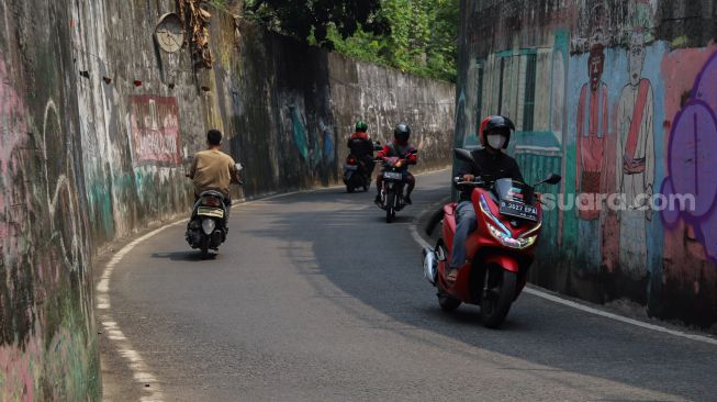 Dinding - dinding yang kusam dan kotor menghiasi sepanjang jalan Terowongan Dipo KRL di Pancoran Mas, Depok, Jawa Barat, Sabtu (26/9). [Suara.com/Alfian Winanto]