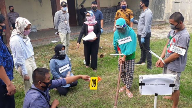 LH dan IS, orang tua yang membunuh anak gara-gara belajar daring saat menjalani rekonstruksi di Mapolres Lebak, Banten, Jumat (25/9/2020). [Foto: BantenHits.com]