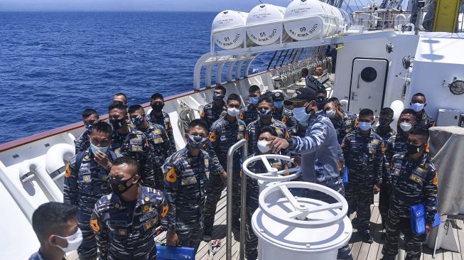 Perwira Layar KRI Bima Suci Lettu Laut (P) Eriec Sugiarto (tengah) memberikan penjelasan fungsi alat-alat yang ada di KRI Bima Suci kepada Taruna dan Taruni AAL tingkat III angkatan ke-67 saat melintas di Selat Bali, Minggu (27/9/2020). [ANTARA FOTO/M Risyal Hidayat]