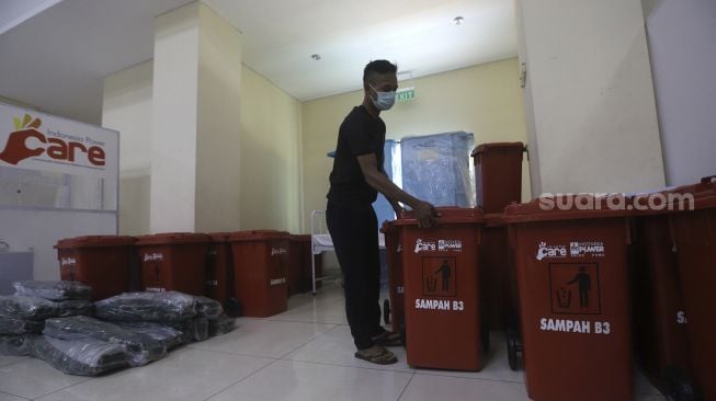 Petugas merapikan ruang isolasi mandiri pasien COVID-19 di GOR Kecamatan Pademangan, Jakarta, Minggu (27/9/2020). [Suara.com/Angga Budhiyanto]