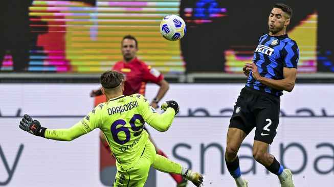 Bek Inter Milan Achraf Hakimi (kanan) berhadapan dengan kiper Fiorentina, Bartlomiej Dragowski dalam pertandingan sepak bola Serie A Italia Inter melawan Fiorentina di stadion Giuseppe-Meazza, Milan pada (26/9/2020). [Miguel MEDINA / AFP]