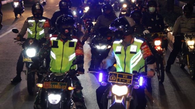 Kapolres Metro Jakarta Selatan Kombes Pol Budi Sartono dan Dandim 0504/Jakarta Selatan Kolonel Inf Ucu Yustiana memimpin patroli bermotor operasi yustisi pendisiplinan protokol kesehatan di Jakarta Selatan, Minggu (27/9/2020) dini hari [ANTARA/HO-Kodim 0504 Jakarta Selatan]. 