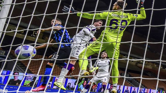 Bek Inter Milan Danilo D'Ambrosio (kiri) mencetak gol kemenangan melewati kiper Fiorentina Bartlomiej Dragowski (kanan) selama pertandingan sepak bola Serie A Italia Inter melawan Fiorentina di stadion Giuseppe-Meazza, Milan pada (26/9/2020). [Miguel MEDINA / AFP]