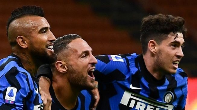 Bek Inter Milan, Danilo Ambrosio (tengah) merayakan gol ke gawang Fiorentina bersama Arturo Vidal (kiri) dan Andrea Bastoni (kanan). Dalam laga yang digelar di Stadion Guiseppe Meazza, Minggu (27/9/2020) dini hari WIB, Inter menang 4-3. (AFP/Miguel Medina)