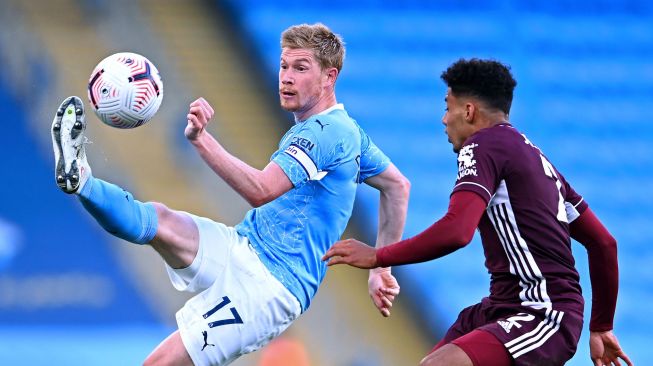 Gelandang Manchester City Kevin De Bruyne (kiri) bersaing dengan bek Leicester City James Justin (kanan) selama selama pertandingan sepak bola Liga Premier Inggris antara Manchester City melawan Leicester City di Etihad Stadium, Manchester, Minggu (27/9/2020). [Laurence Griffiths / POOL / AFP]