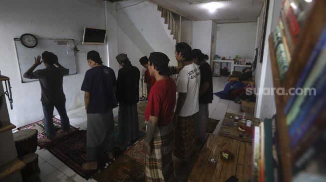 Santri Tasawuf Underground menunaikan shalat Dzuhur berjamaah di Pondok Tasawuf Undergroud, Kompleks Ruko Pasar Cimanggis, Ciputat, Tangerang Selatan, Banten, Selasa (29/9/2020). [Suara.com/Angga Budhiyanto]