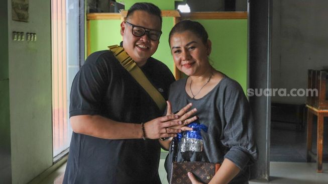 Presenter Reza Bukan bersama istrinya, Serevina Silaen pamer cincin di jari manis mereka ketika difoto di Kawasan Tendean, Jakarta Selatan, Selasa (29/9). [Suara.com/Alfian Winanto]