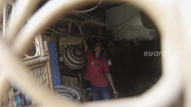 Perajin menata perabot berbahan rotan di Jalan Pasar Minggu, Kalibata, Jakarta, Selasa (29/9/2020). [Suara.com/Angga Budhiyanto]