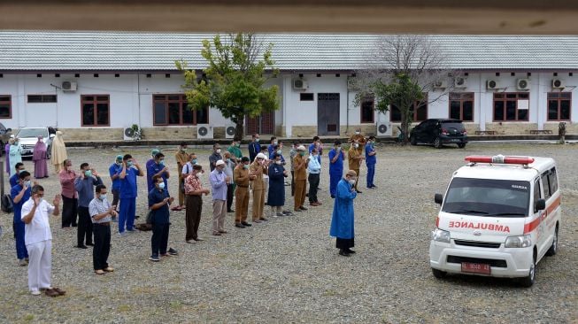 Sejumlah dokter bersama tenaga medis lainnya berdoa setelah melaksanakan shalat jenazah dokter spesialis paru positif COVID-19 saat pelepasan terakhir menggunakan mobil ambulan ke pemakaman di Rumah Sakit Umum Zainainal Abidin, Banda Aceh, Aceh, Selasa (29/9/2020).   [ANTARA FOTO/Ampels]