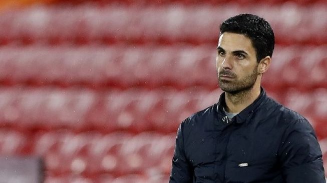 Manajer Arsenal Mikel Arteta menyaksikan skuatnya saat menghadapi tuan rumah Liverpool di Anfield pada laga Liga Inggris. JASON CAIRNDUFF / POOL / AFP