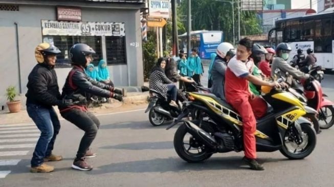 Pemotor menaati imbauan dengan memperagakan menggunakan helm tanpa menunggangi motor (Twitter)