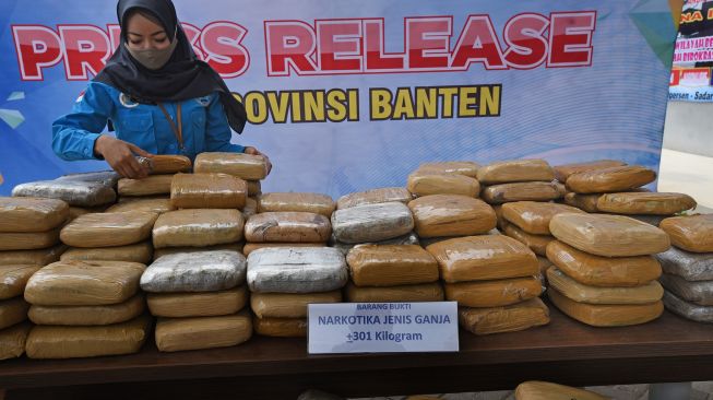 Petugas Badan Narkotika Nasional (BNN) Provinsi Banten menumpuk puluhan paket ganja kering saat rilis penyelundupan ganja dari Aceh di Serang, Banten, Rabu (30/9/2020). [ANTARA FOTO/Asep Fathulrahman]
